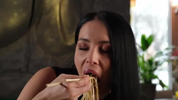 Jolie brune appétissante mange des nouilles — Video