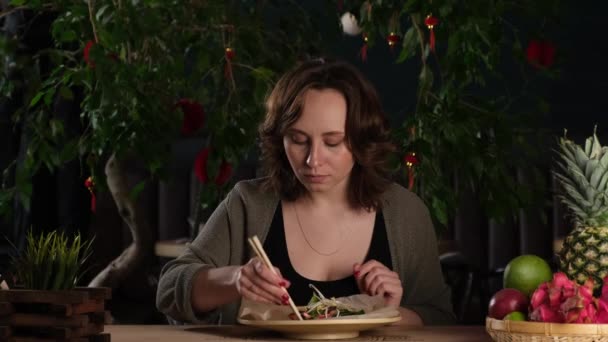 Девушка ест в азиатском ресторане — стоковое видео