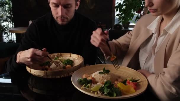 Мальчик и девочка едят азиатскую еду — стоковое видео