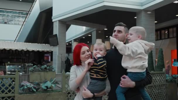 Famille tenant des enfants dans leurs bras au centre commercial — Video