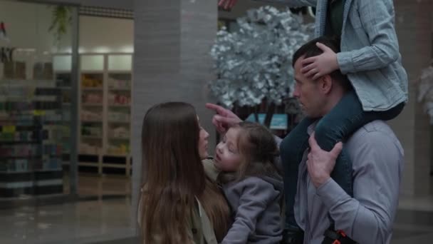 Les enfants dans les bras de leurs parents dans le centre commercial — Video