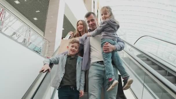 A large family rides down the escalator — Stock Video