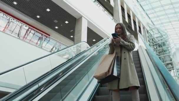 Une femme monte l'escalier roulant. — Video