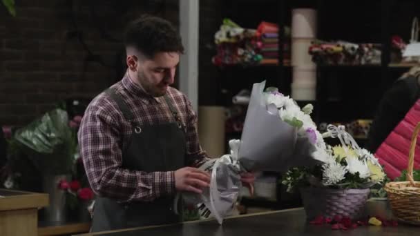 Florist ger en bukett av vita krysantemum till en kund — Stockvideo