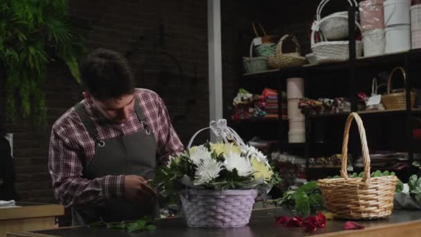 Fiorista che controlla un cesto di crisantemi bianchi — Video Stock
