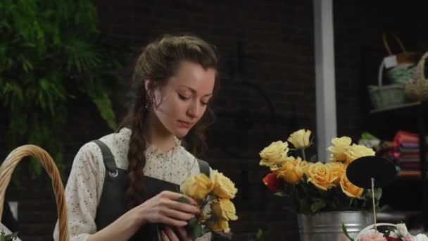 Menina florista coleta um buquê de rosas — Vídeo de Stock