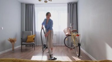 Seksi kız odayı süpürüyor.