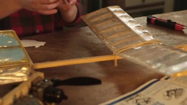 Çocuk uçağa Kanada bayrağının olduğu bir etiket yapıştırıyor.