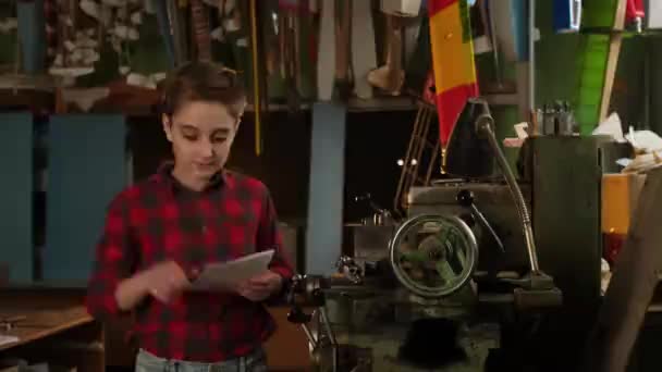 Um adolescente está estudando os meandros do trabalho de um serralheiro — Vídeo de Stock