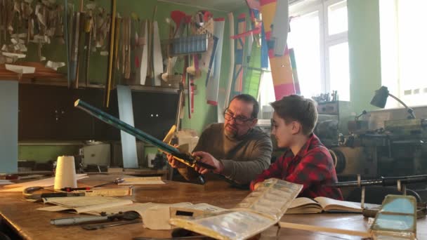 Maestro ayuda a un niño a construir un avión — Vídeo de stock