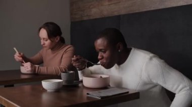 Afro-Amerikalı bir adam bir Japon restoranında öğle yemeği yiyor.