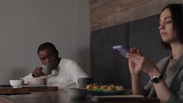 一个黑人在咖啡店里和一个白人女孩调情 — 图库视频影像