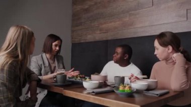 Bir Japon restoranında öğle yemeği yiyen bir arkadaş grubu.