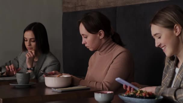 Trois filles à des tables dans un café asiatique Séquence Vidéo