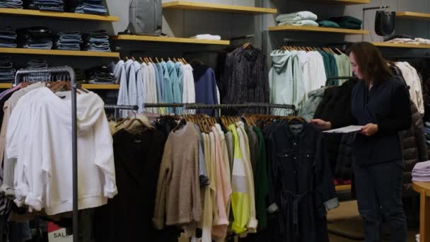 Kierownik sklepu odzieżowego robi inwentaryzację — Wideo stockowe