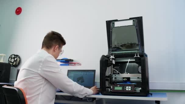 Joven trabajando en una impresora 3D — Vídeos de Stock