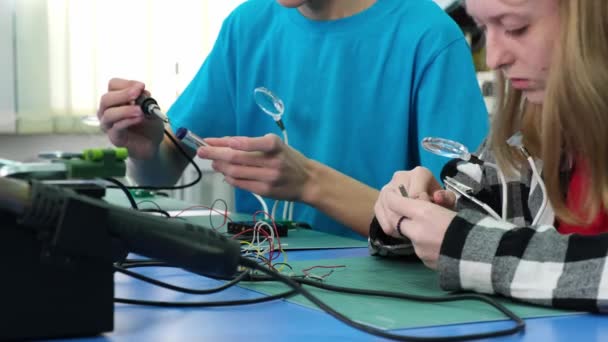 Tonåringar lär sig att arbeta med en elektrisk lödkolv — Stockvideo