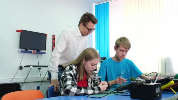 El maestro comprueba el trabajo de los niños con un soldador eléctrico — Vídeos de Stock