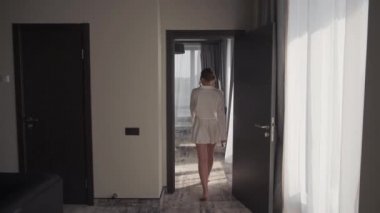 Gelin, otel odasında rahatça dolaşır.