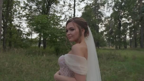 Невеста слегка улыбается и смотрит в камеру. — стоковое видео