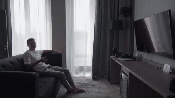 Man rustend in een hotelkamer — Stockvideo