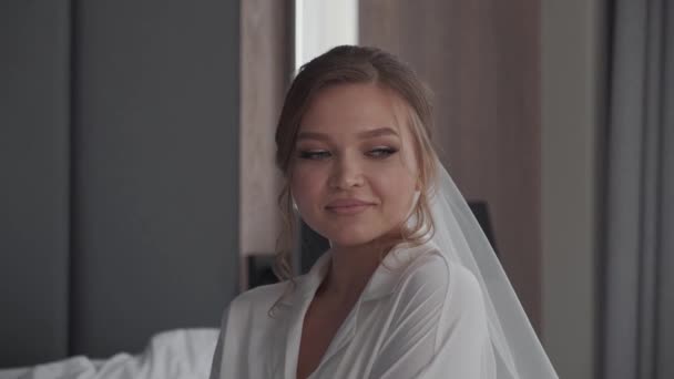 Bruid in een sluier glimlacht schattig naar de camera — Stockvideo