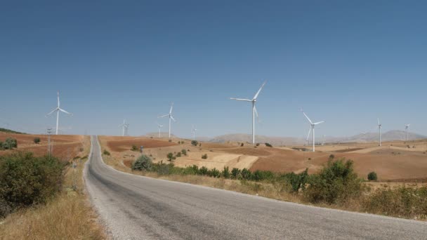 山のクリーンエネルギー生産のための風車農場を通る道路 — ストック動画