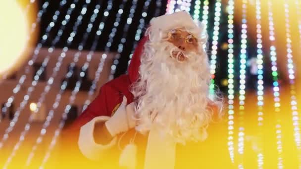 Der Weihnachtsmann jubelt und summt ein Lied auf dem Stadtplatz — Stockvideo