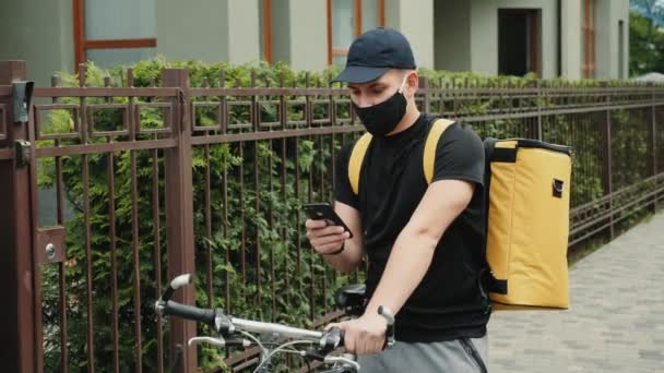 配達人オン自転車チェック方向上の携帯電話 — ストック動画