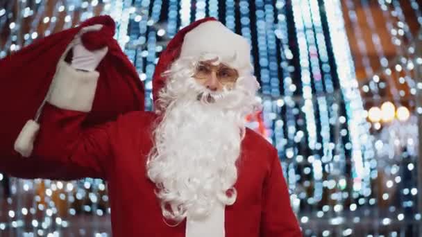 Portret van een gelukkige kerstman op de achtergrond van de stad kerstboom lichten 's nachts — Stockvideo