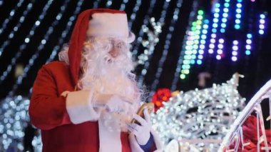 Noel Baba açık havada akıllı telefon kullanır.