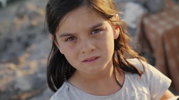 Καππαδοκία, Τουρκία, καλοκαίρι 2021: κοντινό πλάνο ενός μικρού κοριτσιού από φτωχά χωριά και φτωχογειτονιές που κοιτάζει την κάμερα με ενδιαφέρον και ελπίδα — Αρχείο Βίντεο