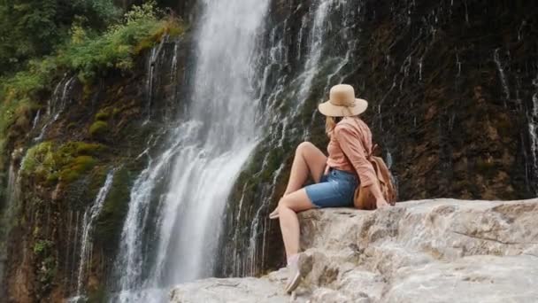 一位年轻女子欣赏瀑布的美丽景色 — 图库视频影像