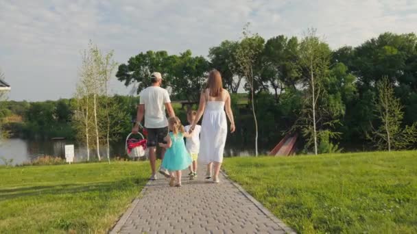 Вид ззаду сім'ї з дітьми збирається мати пікнік і розважатися разом — стокове відео