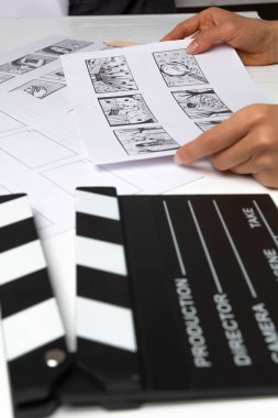 Characters storyboard drawings and movie clapperboard on the artist's desktop.