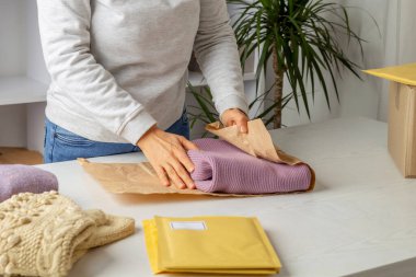 Kadın bağışlanmak için kullanılmış giysileri topluyor. Geri dönüşüm kavramı.