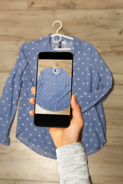Clothing for sale online on a smartphone screen.