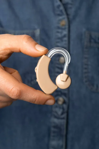 Hearing aid in hand. Close-up.