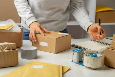 Bir depo işçisi, eşyayı posta kutusuna koymakla meşgul..