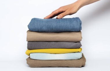 Beyaz arkaplanda katlanmış kıyafet yığını.