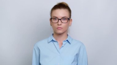 Gözlüklü genç bir iş kadını portresi ve beyaz arka planda bir gömlek..