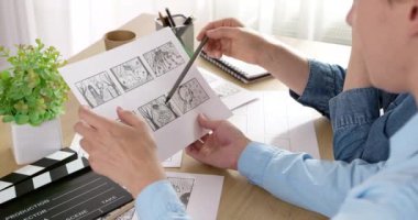 The director and cameraman examine the frames of the storyboard on paper. Drawn characters for the film. Storytelling concept.