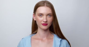Portrait of a smiling young woman looking at the camera. Beautiful girl on a white background.