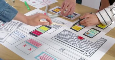 Web tasarımcılarının elleri akıllı telefonlar için uygulama taslakları hazırlıyor. Tasarım mühendisliği ekibinin cep telefonu arayüzü tasarımı.