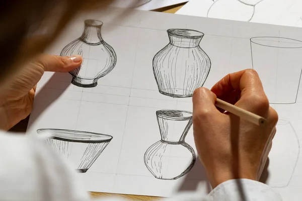 The designer draws sketches of dishes on paper. The artist creates kitchen utensils for production.