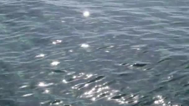 Close-up van rimpels en zonneschijn op het water. Te veel glimmende reflecties van de zon in het water — Stockvideo