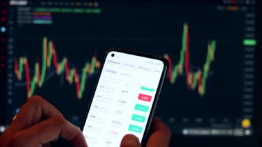 Mobil uygulama ve dizüstü bilgisayar kullanarak finansal analiz, birden fazla aygıt kullanarak borsa simsarlarının risk analizi. Kripto para piyasasında ticaret. Elimde telefon var.