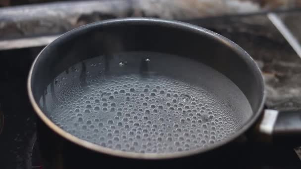 热开水放在平底锅里。烹调食物。在餐厅厨房里烹调食物。煮开水的平底锅. — 图库视频影像