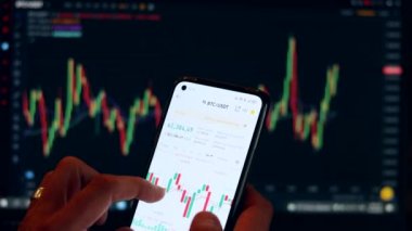 Mobil uygulama ve dizüstü bilgisayar kullanarak finansal analiz, birden fazla aygıt kullanarak borsa simsarlarının risk analizi. Kripto para piyasasında ticaret. Elimde telefon var.