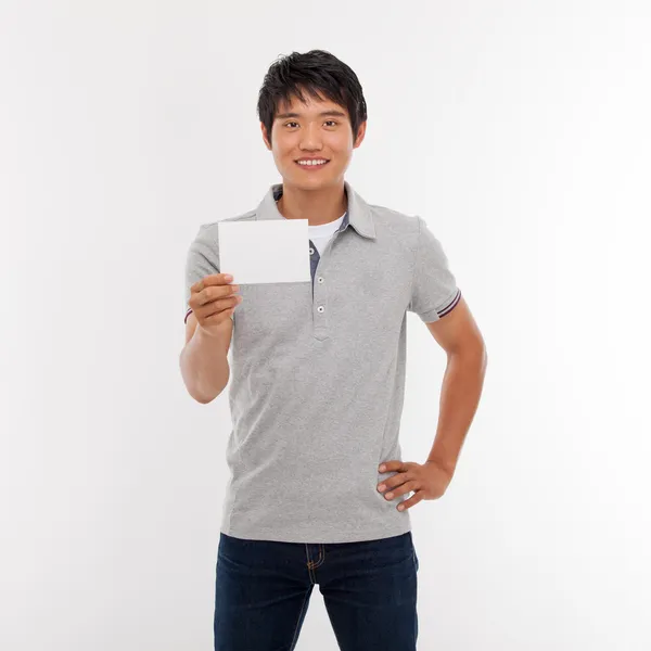 Jovem sorrindo e mostrando cartão vazio . — Fotografia de Stock